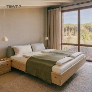 Ein minimalistisches Schlafzimmer von Braum Interior Design mit einem Holzbett, einer grünen Decke, zwei Nachttischen, Hängelampen, einem großen Fenster und beigen Wänden zeigt die eleganten Innenarchitektur-Trends für 2026.