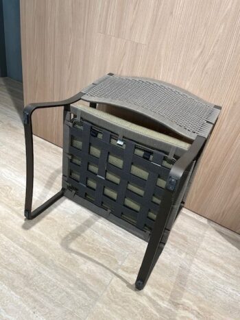 Ein brauner Phoenix Outdoor-Sessel von Molteni&C steht kopfüber auf einem hellen Fliesenboden und lehnt an einer Holzwand.