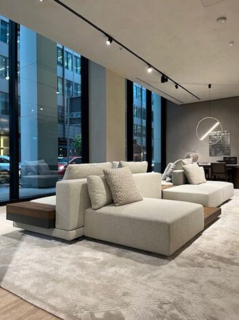 Modernes Wohnzimmer mit zwei Marteen-Sofas von Molteni&C, einem strukturierten Teppich, großen, raumhohen Fenstern und einer runden Leuchte.