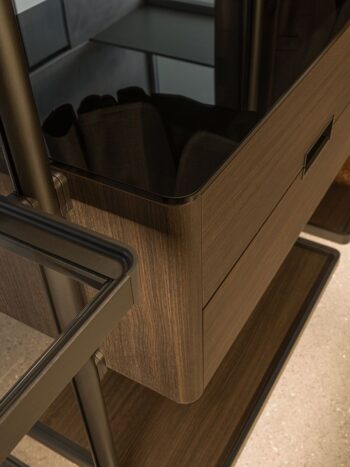 Nahaufnahme eines modernen Molteni&C-Schubladenelements aus Holz mit schwarzem Metallrahmen in einem minimalistischen Ankleidezimmer.