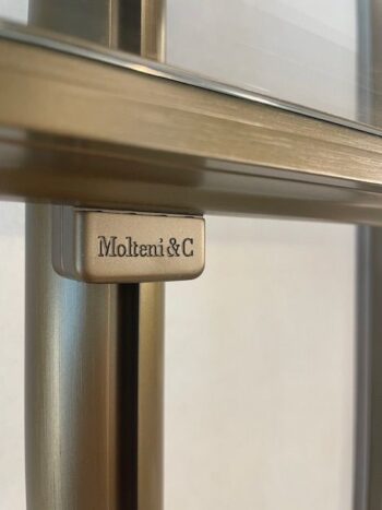 Nahaufnahme eines Regals aus Metall und Glas aus der Kollektion Molteni&C Hector Night mit dem eingravierten Molteni&C-Logo auf einem eleganten Metallbügel.