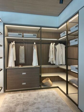 Moderner begehbarer Kleiderschrank Ankleide mit offenen Regalen von Molteni&C Gliss Master, Schubladen, weißer Hängewäsche, Aufbewahrungsboxen und einem geflochtenen Korb. Neutrale Töne und eine eingebaute Beleuchtung vervollständigen den raffinierten Look.