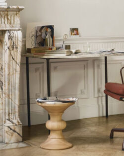 Ein modernes Heimbüro mit einem braunen Drehstuhl, einem hölzernen Beistelltisch, einem Marmorkamin und einem Schreibtisch mit Büchern und Dekorationsgegenständen.
