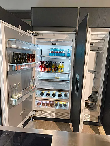 Ein offener Molteni&C-Kühlschrank, gefüllt mit verschiedenen Getränken in Flaschen, darunter Wasser, Limonade, Bier und Wein, übersichtlich angeordnet auf Regalen und in Türfächern - eine elegante Ergänzung für jede Ratio Essenza Küche.