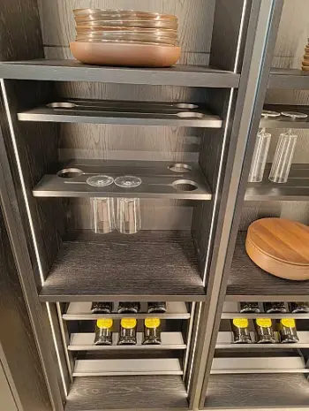 Molteni Abverkauf, Outlet, Angebot: Ein modernes Ratio Essenza Küchenregal mit Glashaltern, leeren Glastassen, gestapelten Tellern und mehreren Gewürzdosen mit gelben Deckeln - perfekt, um Ihre Lieblingsküchengeräte zu präsentieren.