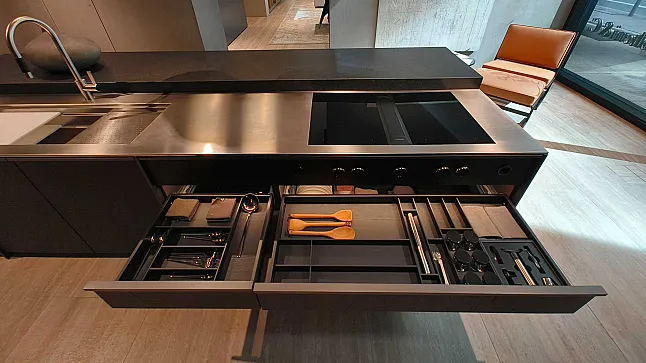 Moderne Küche mit einer Molteni&C Ratio Essenza Küche, die ein offenes Schubladensystem unter einer eleganten Arbeitsplatte aufweist, auf der Küchengeräte und Kochutensilien organisiert sind.