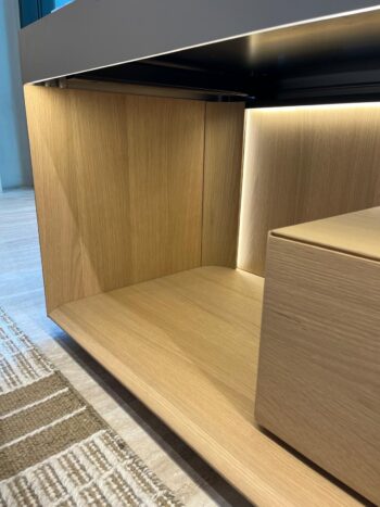 Nahaufnahme eines modernen Molteni&C Living Box Sideboards mit eingebauter LED-Beleuchtung, das sich durch klare Linien und eine helle Holzoberfläche auf der Innenseite und dem Sockel auszeichnet.