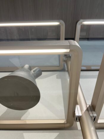 Ein Metallobjekt, das hinter Glasscheiben mit integrierter LED-Beleuchtung auf einer hellen Fläche steht, zeigt die Eleganz des Molteni&C Hector Regalsystems.