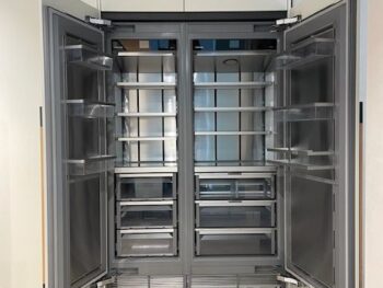 Molteni Abverkauf, Outlet, Angebot: Ein großer, leerer, doppeltüriger Kühlschrank mit mehreren Fächern und Schubladen steht offen in einer modernen Küche und fügt sich nahtlos in das elegante Intersection-Design von Molteni&C ein.