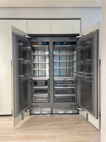 Molteni Abverkauf, Outlet, Angebot: Ein großer, leerer, doppeltüriger Kühlschrank mit mehreren Fächern und Schubladen steht offen in einer modernen Küche und fügt sich nahtlos in das elegante Intersection-Design von Molteni&C ein.