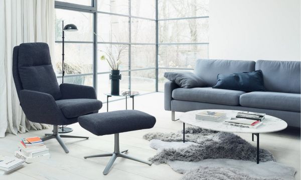 Modernes Wohnzimmer mit großem Fenster, grauem Sessel und Ottomane, grauem Sofa, rundem Marmor-Couchtisch, Zottelteppich und minimalistischem Dekor - entdecken Sie diesen Stil im Möbelhaus Bad Homburg. Modernes Wohnzimmer mit großem Fenster, grauem Sessel und Ottomane, grauem Sofa, rundem Marmor-Couchtisch, Zottelteppich und minimalistischem Dekor - entdecken Sie diesen Stil im Möbelhaus Bad Homburg.