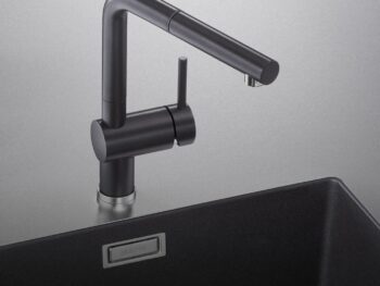 Mattschwarze Küchenarmatur Blanco Linus Armatur mit einem Griff, installiert auf einem passenden schwarzen Spülbecken vor hellgrauem Hintergrund.