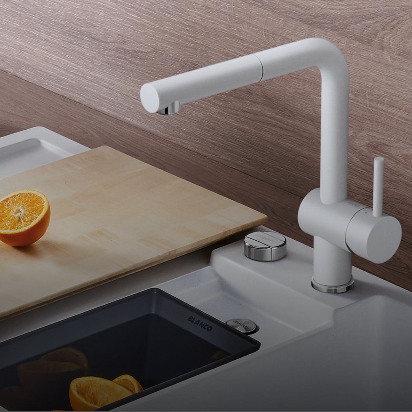 Eine moderne Blanco Linus Armatur in Weiß steht neben einem Waschbecken, ergänzt durch ein hölzernes Schneidebrett mit einer halbierten Orange.