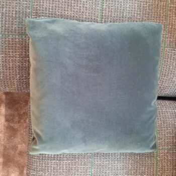 Ein schlichtes, quadratisches, grünes Kissen auf einem grauen, strukturierten Carré-Sofa verleiht dem Ambiente einen Hauch von Frische und Stil.