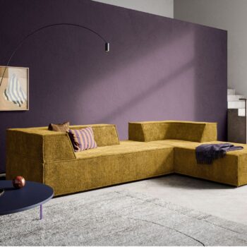 Modernes Wohnzimmer mit einem COR Sofa Trio in Senfgelb, einer lila Akzentwand, abstrakter Wandkunst, einer modernen Stehlampe und einem runden blauen Couchtisch auf einem hellen Teppich.