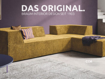Modernes, senfgelbes Ecksofa mit violetten Zierkissen in einem zeitgenössischen Wohnzimmer mit violetten Wänden. An der Wand steht in weißer Schrift: „DAS ORIGINAL“. Erleben Sie zeitlosen Stil mit Braum Interior Design – SEIT 1903.