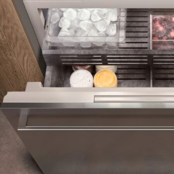 Gaggenau 400 Vario Serie: Öffnen Sie die Gefrierschublade des Gaggenau 400, in der sich eine Schale mit Eiswürfeln, ein Teil mit gefrorenen Beeren und mehrere Behälter mit Eis oder gefrorenen Desserts befinden.