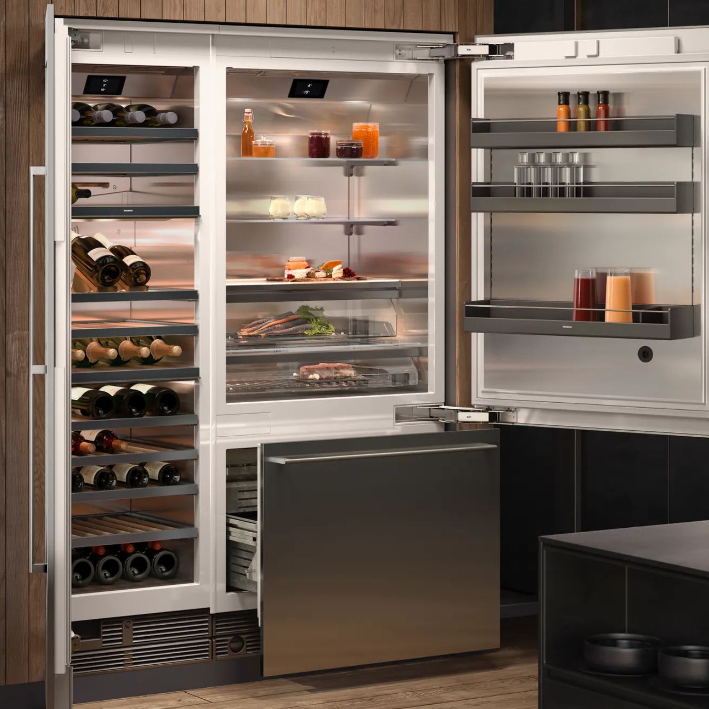 Offener moderner Kühlschrank von Gaggenau mit ordentlich angeordneten Weinflaschen, Getränken, Gewürzen und Lebensmitteln auf Ablagen, neben einer Gefrierschublade der Vario Serie 400, in einer modernen Küche.
