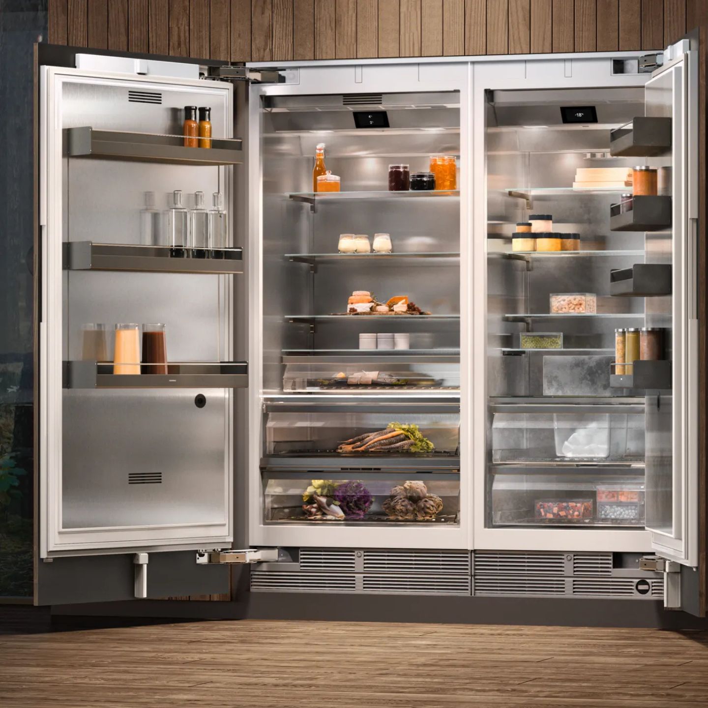 Ein moderner Gaggenau 400 Doppeltür-Kühlschrank mit offenen Türen zeigt in einer Küche mit Holzvertäfelung auf Glasablagen ordentlich geordnete Lebensmittel, Getränke, Gewürze und Produkte.