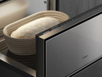 Gaggenau Expressive: Ein Laib Teig ruht in einem Banneton in einer Gaggenau Wärmeschublade mit teilweise geöffneter Tür, die das elegante Design der Expressive Serie in einer modernen Küche zur Geltung bringt.