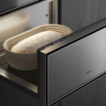 Gaggenau Expressive: Ein Laib Teig ruht in einem Banneton in einer Gaggenau Wärmeschublade mit teilweise geöffneter Tür, die das elegante Design der Expressive Serie in einer modernen Küche zur Geltung bringt.