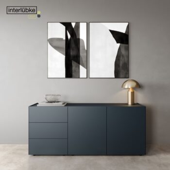 Minimalistisches Zimmer mit einem Interlübke-Sideboard in Dunkelblau, einer Glasschale, einer goldenen Lampe und zwei abstrakten Schwarz-Weiß-Bildern an einer grauen Wand. Das Interlübke-Logo in der oberen linken Ecke ist der perfekte Start in ein raffiniertes Leben.