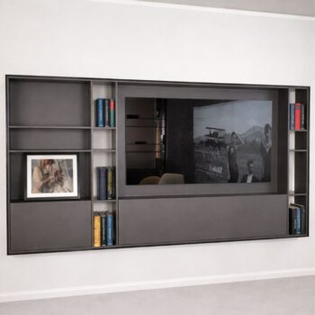 Ein modernes Interlübke TV-Wandregal mit Büchern, einem gerahmten Foto und einem eingebauten Fernseher, der eine Schwarz-Weiß-Szene zeigt.
