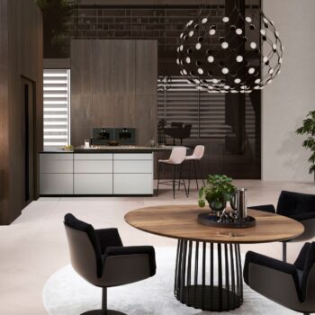 Leicht Küchen Contino E12 - Moderne Küche und Essbereich mit rundem Holztisch und schwarzen Stühlen, minimalistischen Schränken, Barhockern, einer skulpturalen Hängelampe und großen Jalousien.