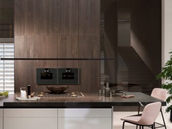 Leicht Küchen Contino E12 - Moderne Küche mit dunklem Holzsockel, eingebautem Ofen, Herd, Marmorarbeitsplatte, rosa Stühlen und minimalistischem Dekor.