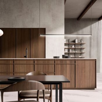 Leicht Küchen KYOTO - Moderne Küche mit Holzschränken, einer minimalistischen Leuchte, offenen Regalen mit Geschirr und einem schwarzen Esstisch mit Stühlen im Vordergrund.