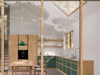 Leicht Küchen KYOTO - Moderne Küche mit grünen Schränken, hölzernen Akzenten und einem Esstisch; ein großes Fenster und ein Dachfenster sorgen für natürliches Licht, und man kann die Bäume draußen sehen.
