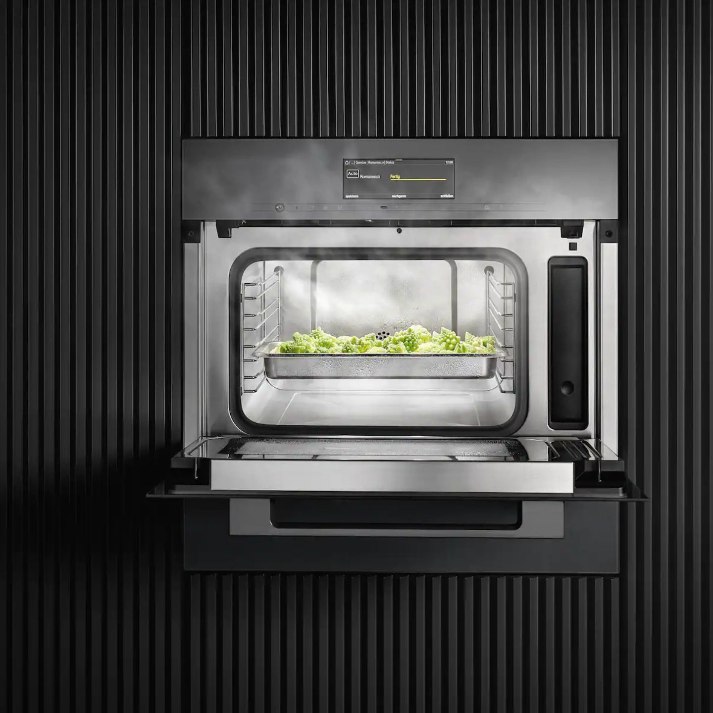 Der Miele-Dampfgarer DGM 7440 zeigt bei geöffneter Tür eine Schale mit gedämpftem Gemüse vor einem dunklen, vertikalen Hintergrund. Das vielseitige Gerät verfügt auch über eine integrierte Mikrowelle.
