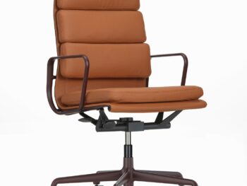 Vitra Soft Pad Chair aus braunem Leder mit gepolsterter Sitzfläche und Rückenlehne, Armlehnen aus Metall und einem Fußkreuz mit fünf Rädern auf weißem Grund.
