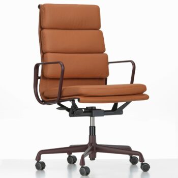 Vitra Soft Pad Chair aus braunem Leder mit gepolsterter Sitzfläche und Rückenlehne, Armlehnen aus Metall und einem Fußkreuz mit fünf Rädern auf weißem Grund.