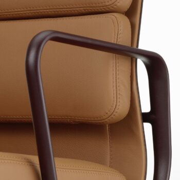 Nahaufnahme eines Vitra EA 217 Soft Pad Chair mit hellbraunem Lederbezug und einer dunkelbraunen Metallarmlehne.