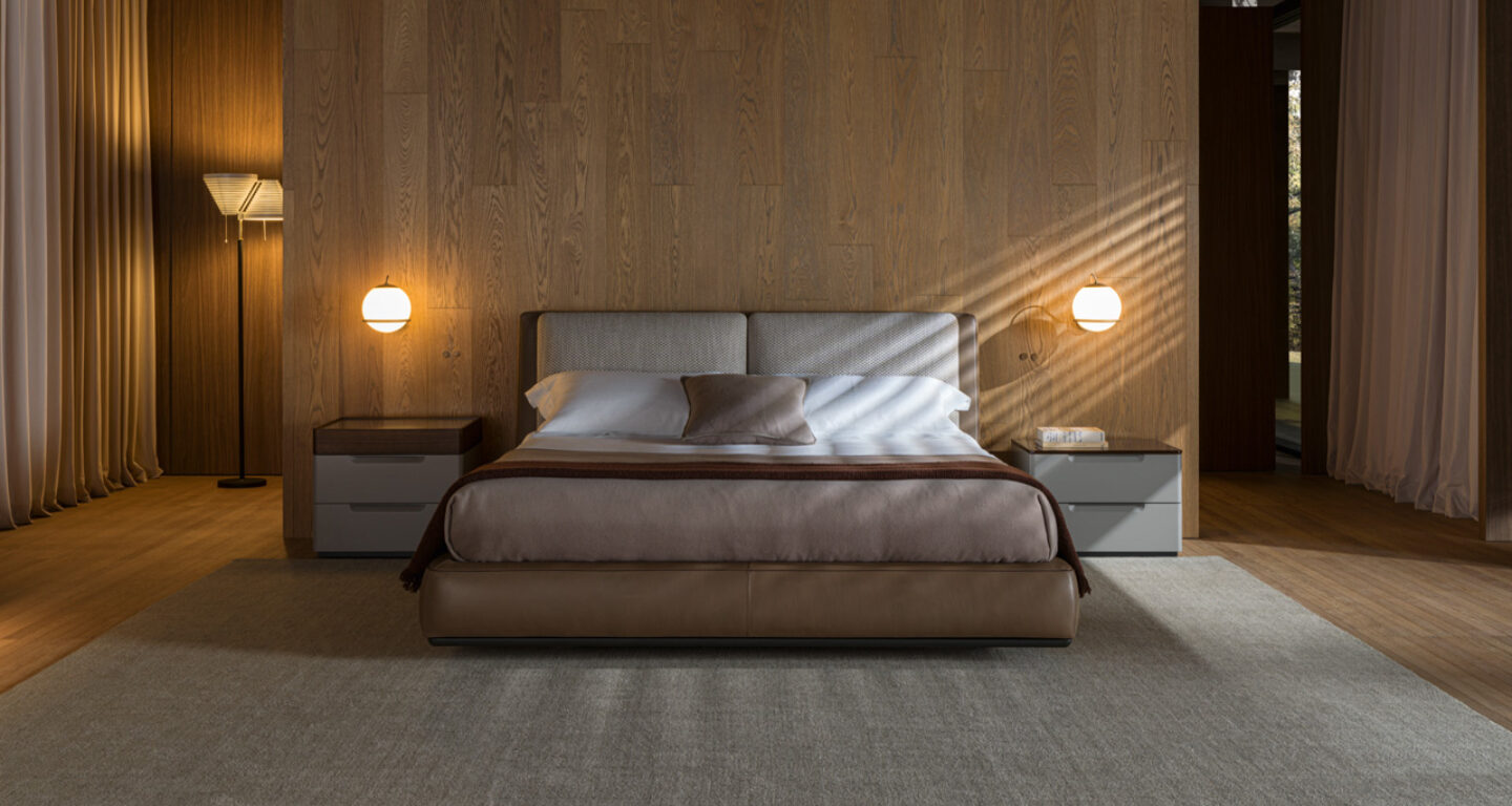 Modernes Schlafzimmer mit einem großen Bett, zwei Nachttischen mit Lampen, einer Stehlampe, einer holzgetäfelten Wand und einem Dekor in neutralen Farben.