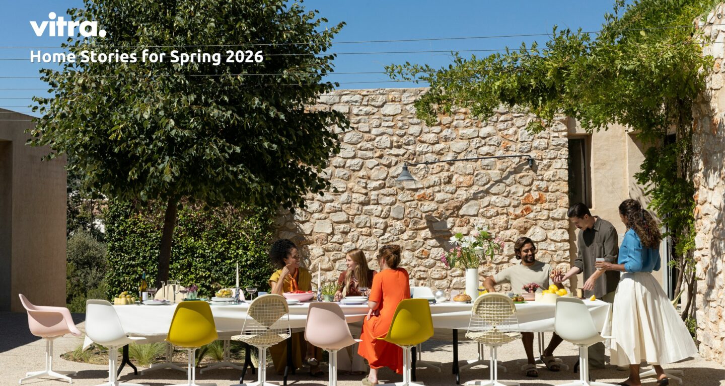 Eine Gruppe von Menschen versammelt sich um einen Vitra Outdoor-Esstisch mit modernen Designklassiker-Stühlen und genießt eine Mahlzeit in einem sonnigen Innenhof mit Steinmauern und Grünflächen. Der Text lautet: vitra. Home Stories für Frühjahr 2026. Eine Gruppe von Menschen versammelt sich um einen Vitra Outdoor-Esstisch mit modernen Designklassiker-Stühlen und genießt eine Mahlzeit in einem sonnigen Innenhof mit Steinmauern und Grünflächen. Der Text lautet: vitra. Home Stories für Frühjahr 2026.