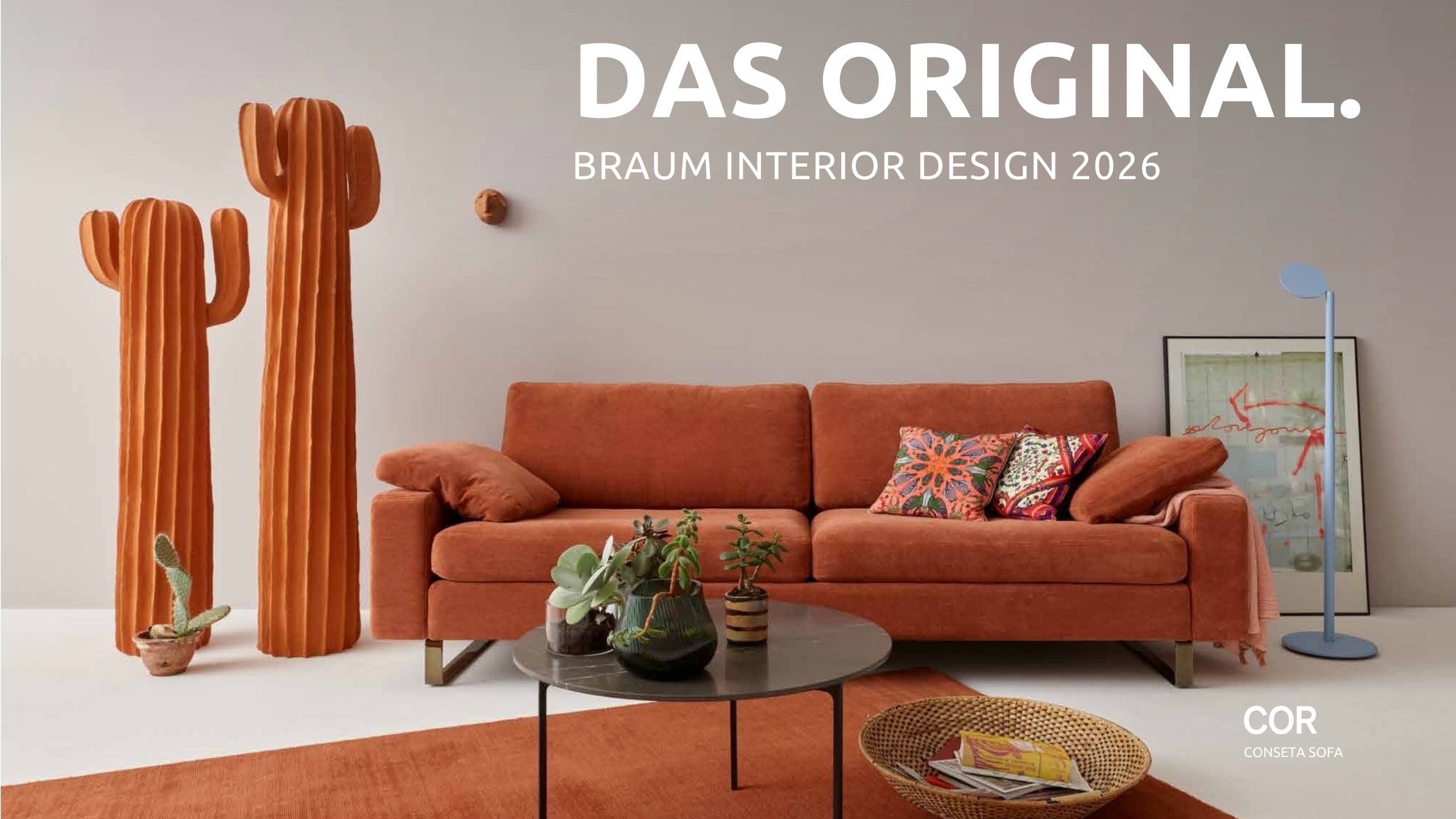 Ein modernes Wohnzimmer von Braum Interior Design mit einem rostfarbenen Sofa, orangefarbenen Kaktusskulpturen, einer blauen Stehlampe und dekorativer Kunst; Text überlagert das Bild. Räume die wirken - erleben Sie die Zukunft von Interior Design 2026.