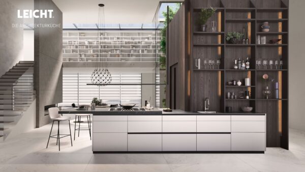 Moderne Architekturküche mit einer großen Insel, offenen Regalen, dunklen Holzakzenten und minimalistischem Design von LEICHT. Eine offene Treppe und ein hochgelegener Bibliotheksbereich verleihen diesem von Möbel Braum inspirierten Raum mehr Tiefe.